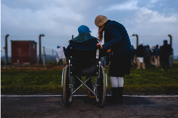 Disabled person in a wheelchair with a friend.